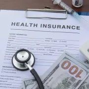 picture of a health insurance form a calculator and money